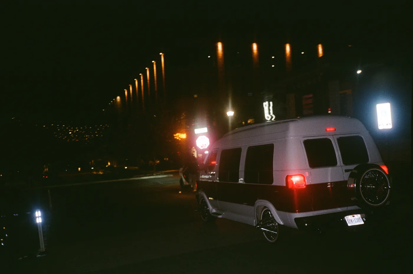 A van under street lights on a dark Austin street