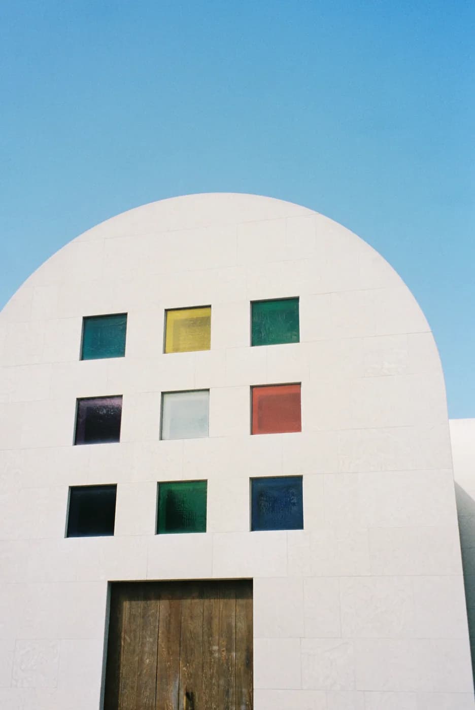 A white Austin building with a grid of coloured squares